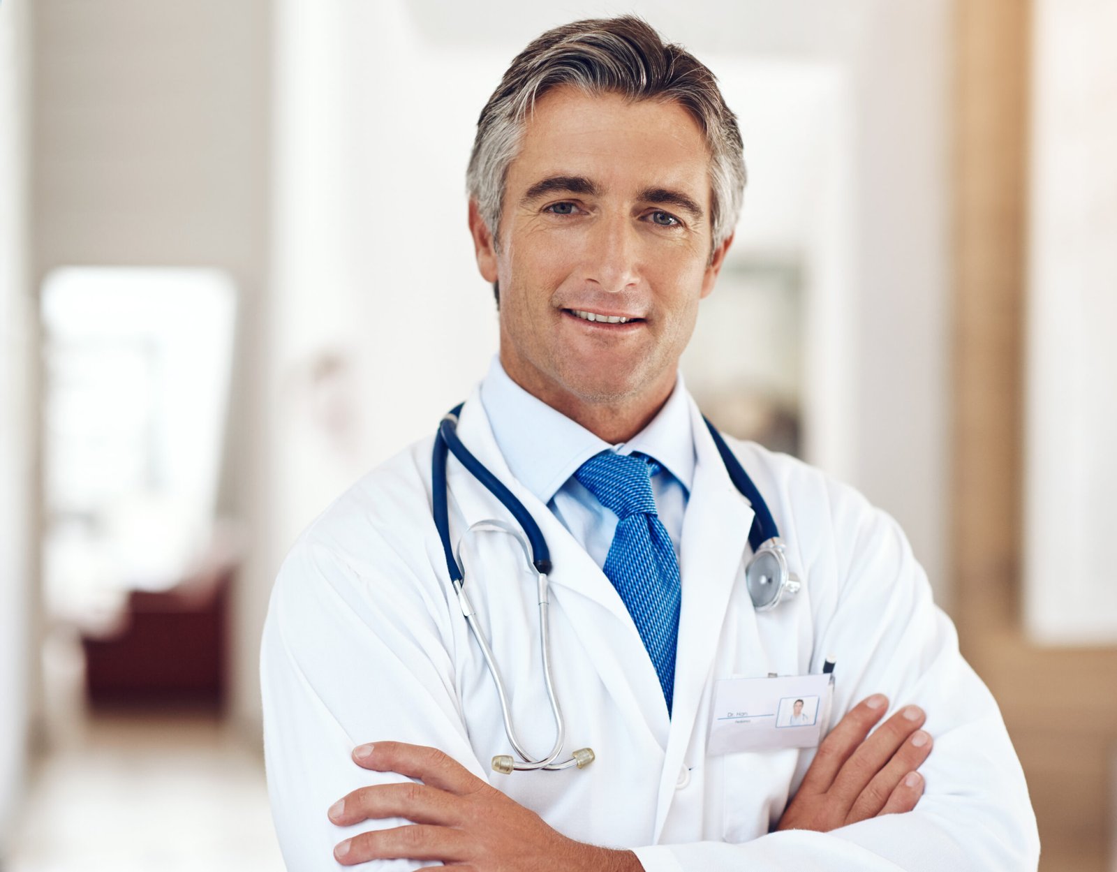Smile, healthcare and portrait of doctor with crossed arms in hospital with positive, confident and pride. Happy, medical and professional mature male cardiology surgeon from Australia work in clinic.